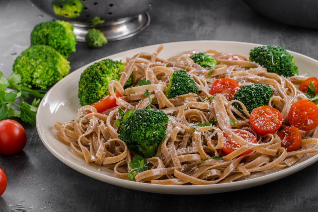 Whole wheat vegetable pasta with broccoli, cherry tomatoes and fresh herbs