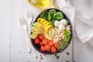 Healthy bowl with fresh vegetables, avocado, grains and seeds for balanced nutrition