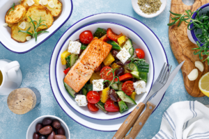 Mediterranean grilled salmon bowl with fresh vegetables, feta cheese and olives