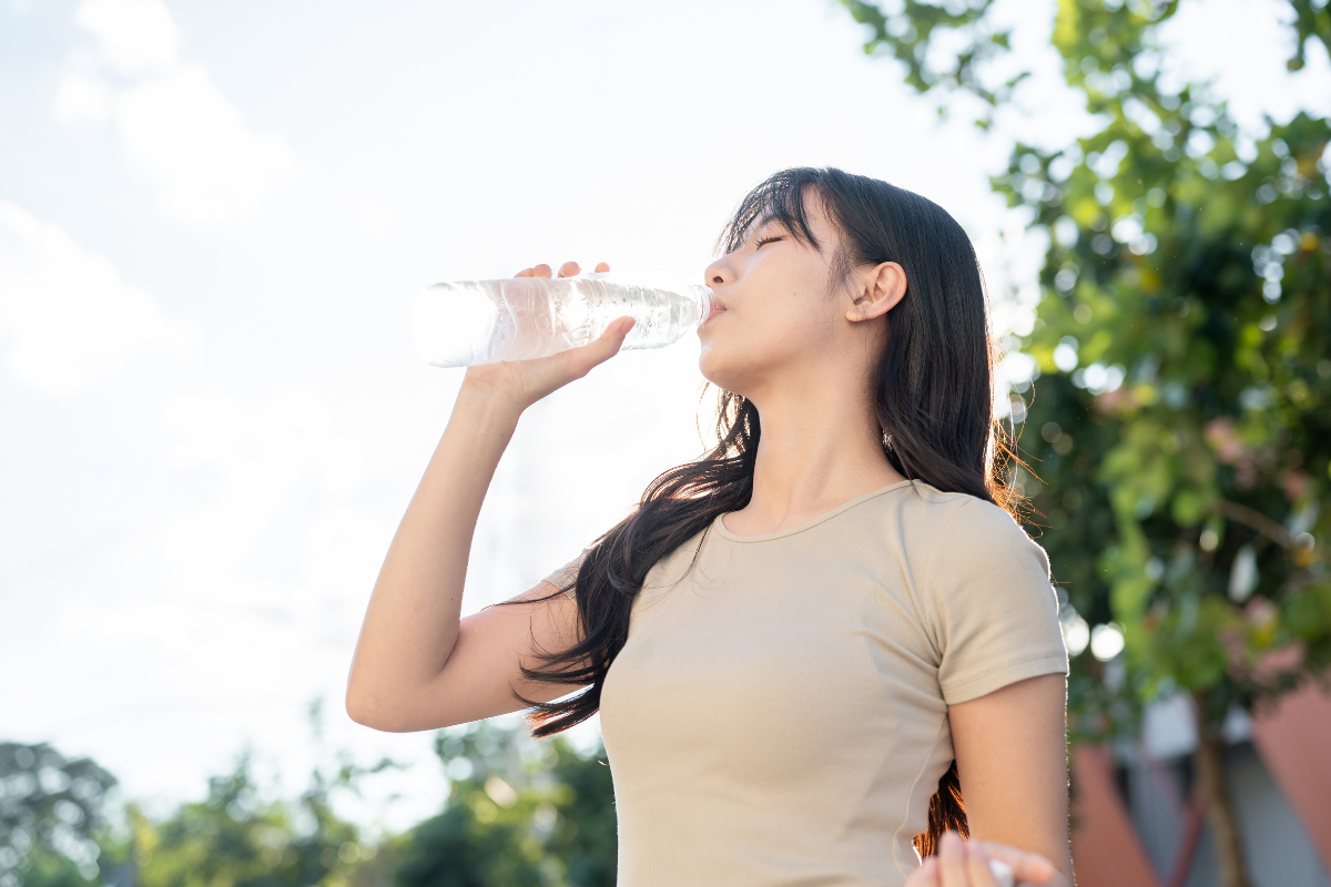 Woman drinking water outdoors