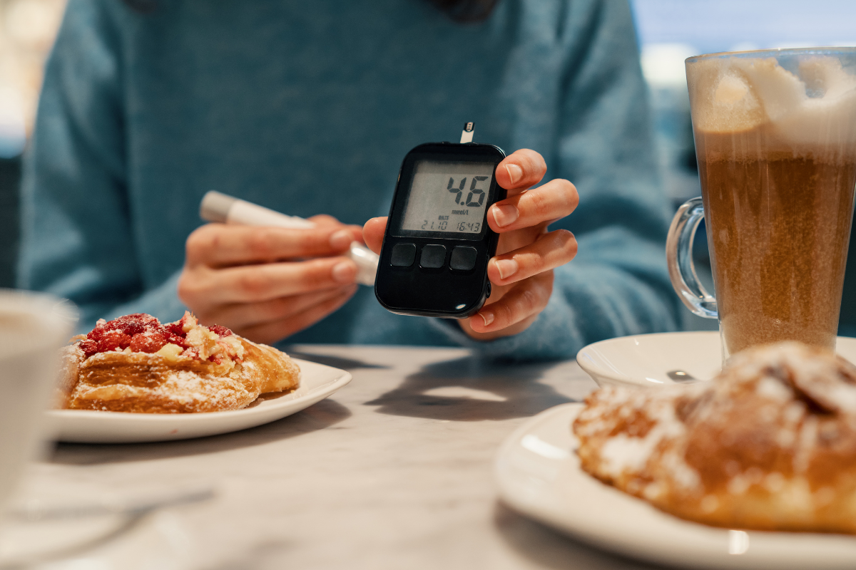 Person checking blood glucose with a glucose meter before eating a meal