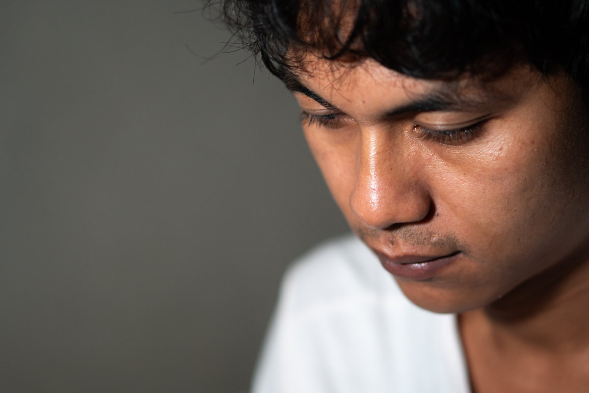 Person looking down thoughtfully representing awareness of fatty liver and hidden health conditions