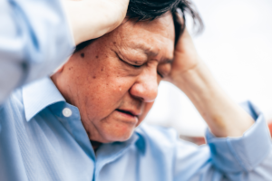 Man holding his head in pain while experiencing a severe headache.