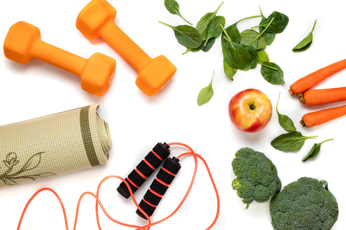 Healthy lifestyle with exercise equipment, fresh vegetables and fruit