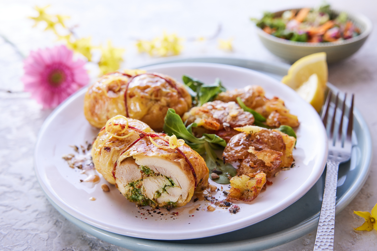 Healthy stuffed chicken served with roasted potatoes, greens and lemon