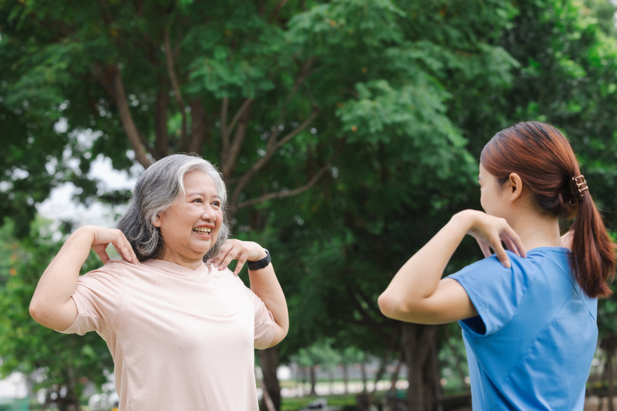 Older woman exercising outdoors with a younger woman to support joint health and mobility