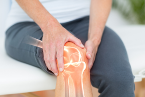 Person holding a painful knee with an illustration highlighting the knee joint