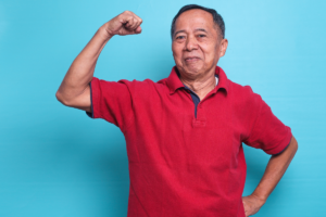 Older man flexing his arm to represent muscle strength and healthy ageing