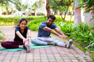 Man and woman stretching outdoors as part of an active lifestyle.