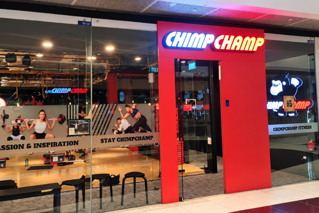 Entrance to ChimpChamp Fitness at Marina Square with red signage and a glass-fronted workout studio